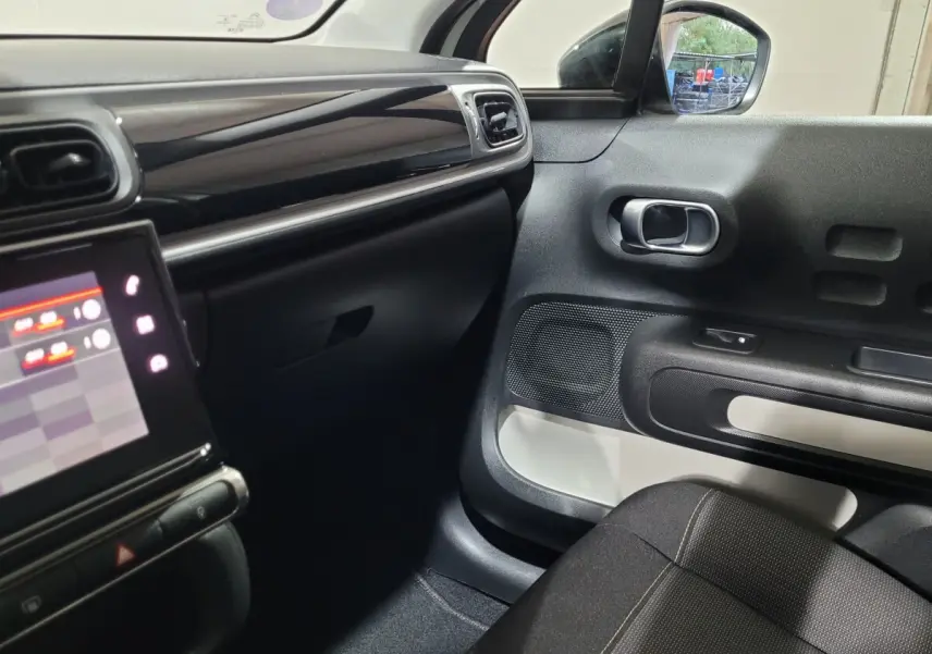 Intérieur avant droit de la Citroën C3 beige 2022, avec tableau de bord noir brillant et écran tactile central.