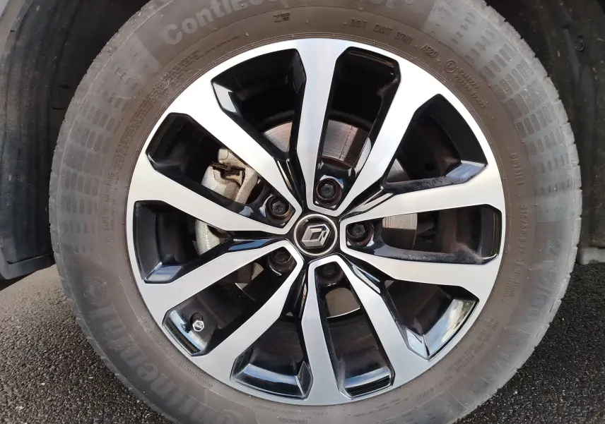 Gros plan sur la jante alliage bicolore noir et argent avec logo Renault au centre du Renault Kadjar gris Titanium.