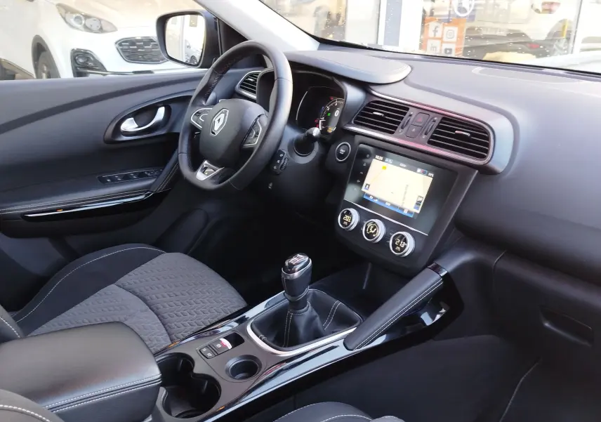 Vue intérieure côté conducteur du Renault Kadjar 1.3 TCe 140ch 2021, avec tableau de bord noir, volant multifonction et boîte manuelle.