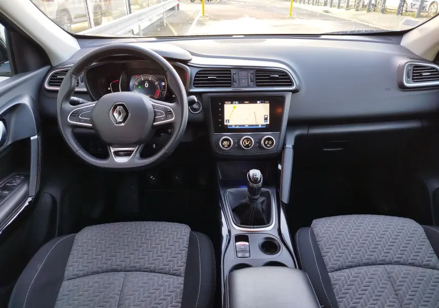 Vue intérieure avant du Renault Kadjar 1.3 TCe 140ch 2021, avec tableau de bord gris, volant multifonction et écran tactile central.