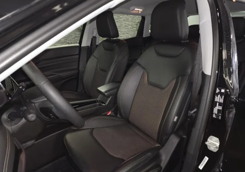 Vue intérieure côté conducteur du Jeep Compass 2024 noir, sièges avant en cuir et tissu noir avec surpiqûres bronze.