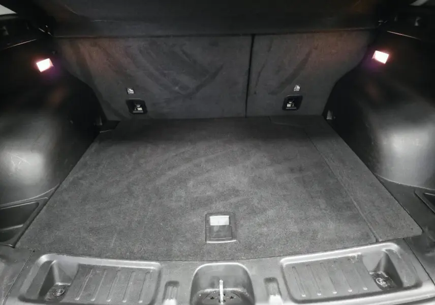 Coffre noir spacieux de Jeep Compass 2024, vue intérieure arrière avec éclairage d’ambiance et tapis en tissu.