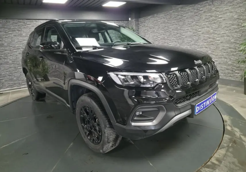 Jeep Compass noir en vue 3/4 avant droit, avec jantes noires et calandre distinctive à sept fentes.