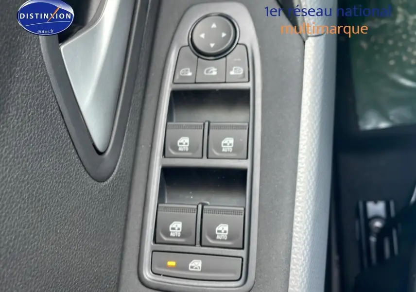 Gros plan sur les commandes des vitres électriques côté conducteur d'un Dacia Duster 2026, intérieur noir.