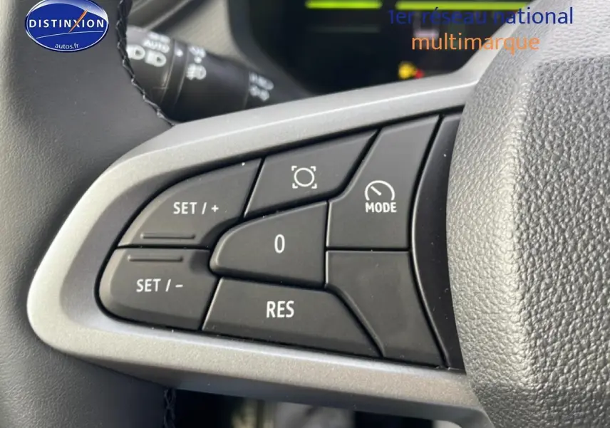 Gros plan sur les commandes multifonctions noires à gauche du volant du Dacia Duster 2026, intérieur gris.