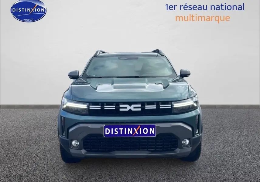 Vue frontale d'un Dacia Duster 1.2 mild hybrid 140 Journey vert cèdre avec phares LED allumés et calandre noire.