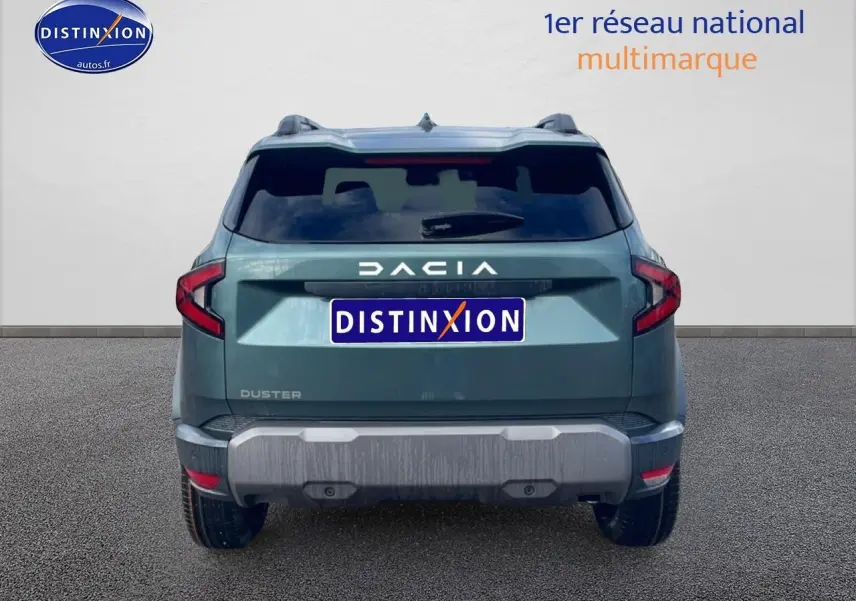 Vue arrière d'un Dacia Duster 2026 vert cèdre avec barres de toit et feux arrière LED distinctifs.