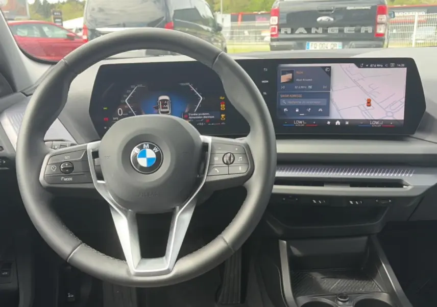 Vue intérieure frontale du volant cuir noir et tableau de bord numérique de la BMW Série 1 120da M Sport 2025.