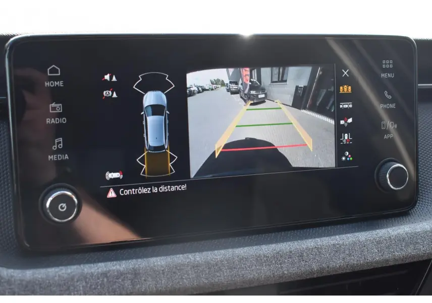 Écran central montrant la caméra de recul et les capteurs de distance du Skoda Scala gris graphite, vue intérieure.