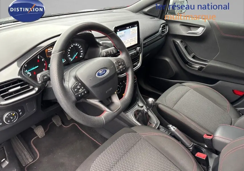 Intérieur du Ford Puma 2022 vu côté conducteur, tableau de bord moderne avec écran tactile et volant cuir perforé noir.