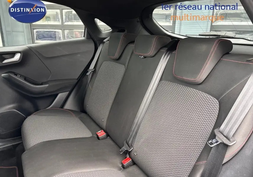 Vue du siège arrière côté gauche d'une Ford Puma 2022, tissu noir avec surpiqûres rouges et ceintures grises.