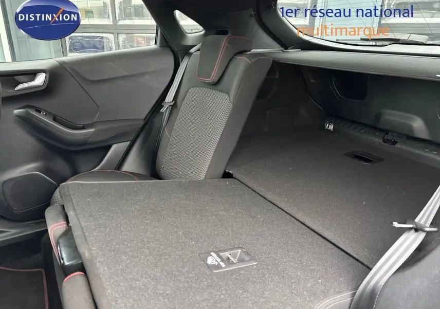 Vue intérieure arrière du Ford Puma gris Solar montrant les sièges rabattus et l'espace de chargement étendu.