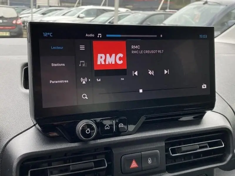 Écran tactile central du Citroën Berlingo gris Artense 2025 affichant la radio RMC, vue intérieure frontale.