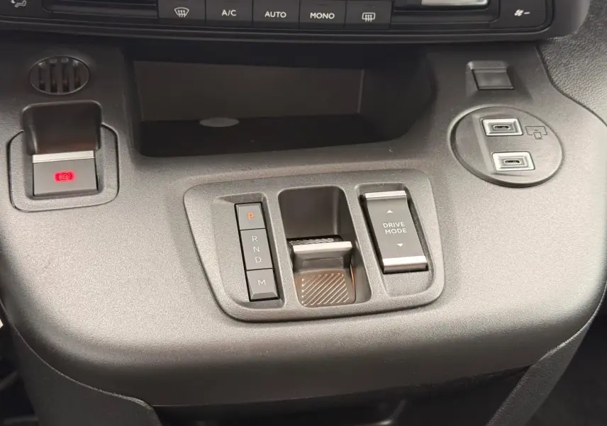 Vue rapprochée de la console centrale noire du Citroën Berlingo 2025, avec commandes de boîte auto et mode de conduite.