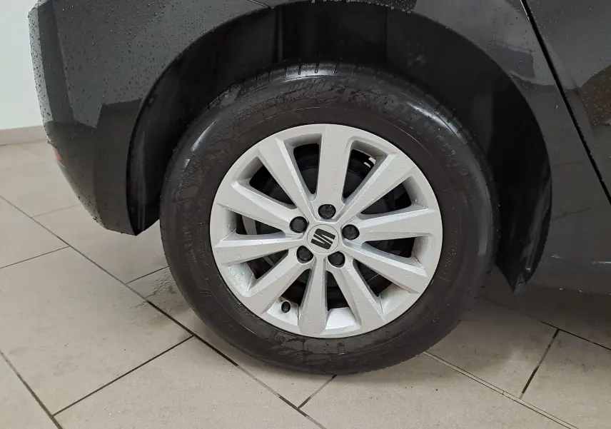 Gros plan sur la roue arrière gauche de la SEAT IBIZA 2024 noir minuit avec jante alliage 15'' Enjoy mouillée.