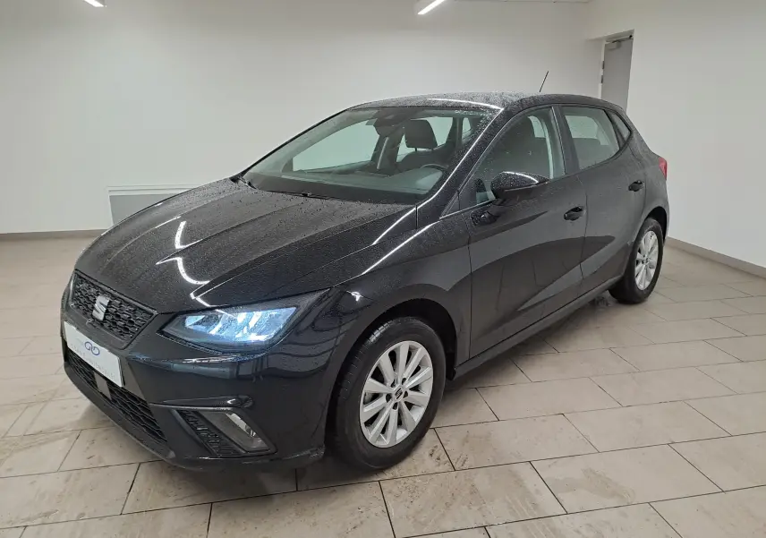 SEAT Ibiza 2024 noir minuit vue 3/4 avant droit avec projecteurs EcoLED allumés et jantes alliage 15 pouces.