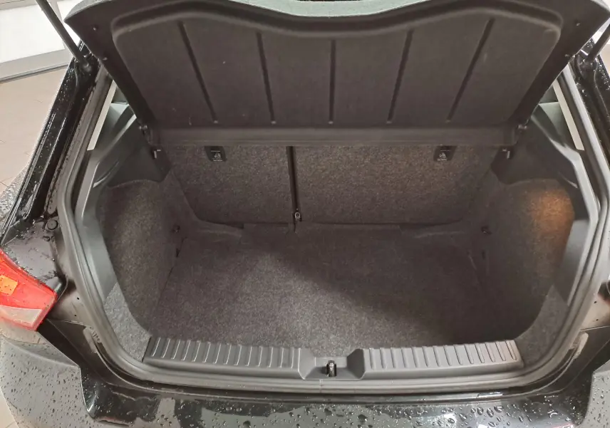 Coffre ouvert vu de l'arrière d'une SEAT Ibiza noir minuit 2024, montrant l'espace de chargement vide et la garniture intérieure.