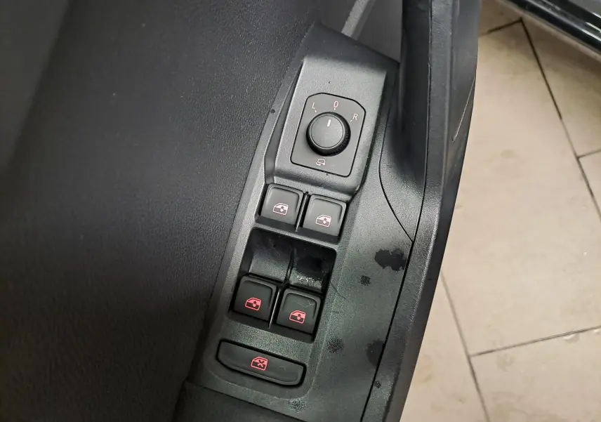 Gros plan sur les commandes des vitres et rétroviseurs côté conducteur d’une SEAT Ibiza noir minuit 2024.