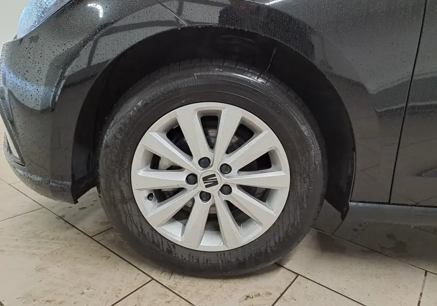 Gros plan sur la roue avant gauche avec jante alliage 15'' Enjoy de la SEAT Ibiza noir minuit 2024.