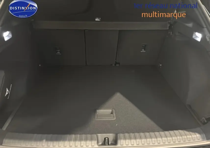 Coffre ouvert vu de l'arrière d'une CUPRA TERRAMAR noire, espace de chargement vide et tapis noir.