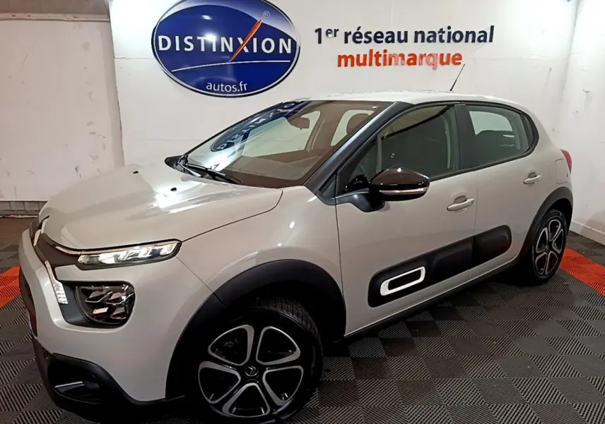 Citroën C3 beige vue 3/4 avant droit, avec protections latérales noires et jantes originales en alliage.