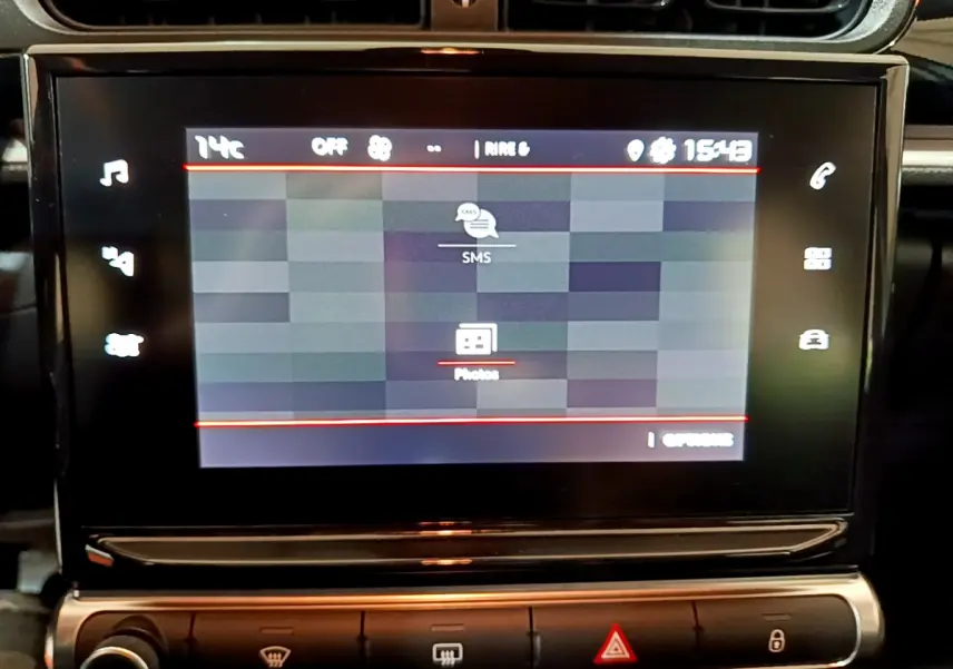 Écran tactile central de la Citroën C3 beige 2022 affichant les options SMS et photos, vue frontale rapprochée.