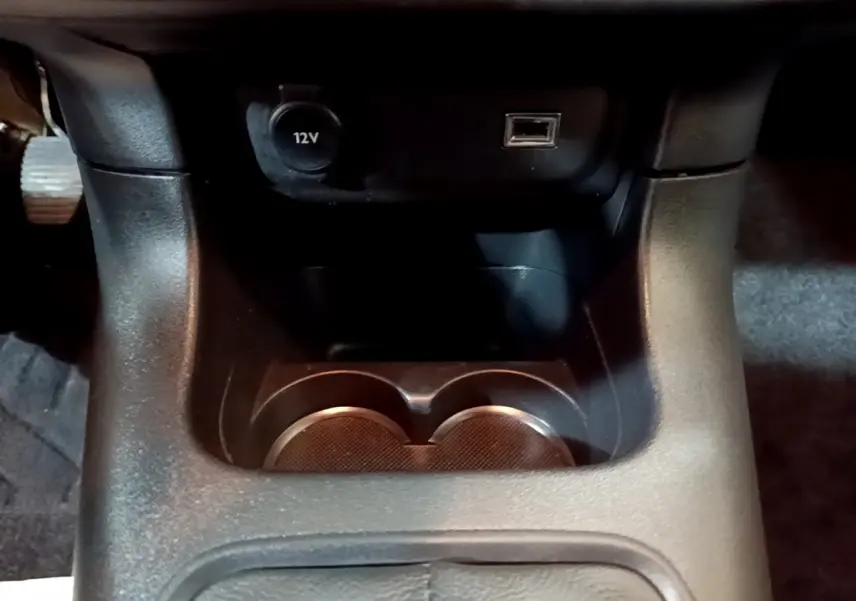 Gros plan sur la console centrale noire de la Citroën C3 avec prise 12V et port USB visible.