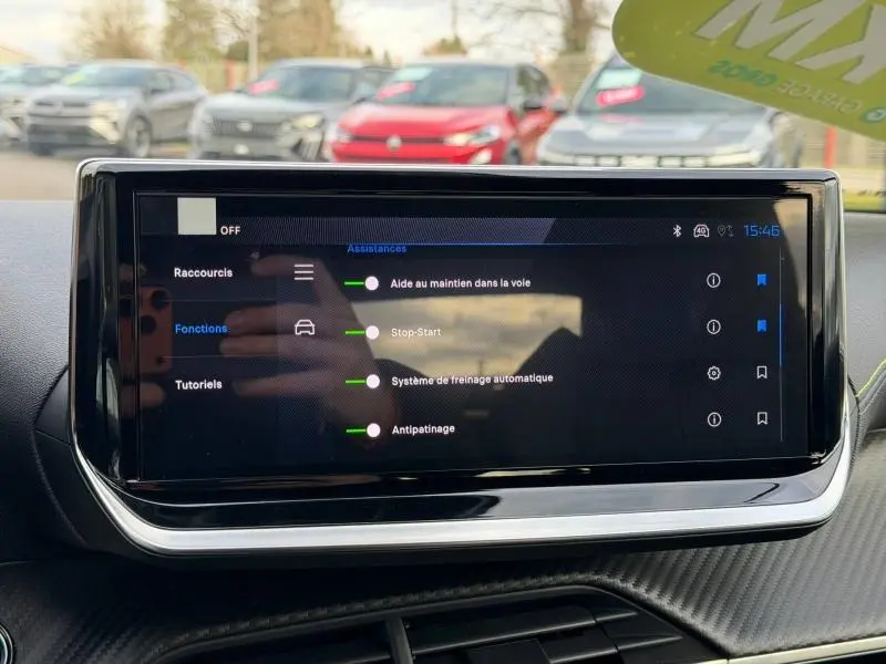 Écran tactile central de la Peugeot 2008 Hybrid 145ch GT, vue intérieure frontale avec menu d'assistances activées.