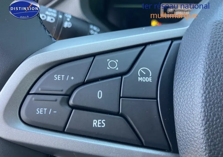 Gros plan sur les commandes multifonctions à gauche du volant du Dacia Duster gris schiste 2026.