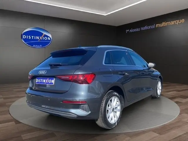Vue 3/4 arrière droite d'une Audi A3 30 TDI Business Line gris foncé, avec feux LED et jantes argentées visibles.