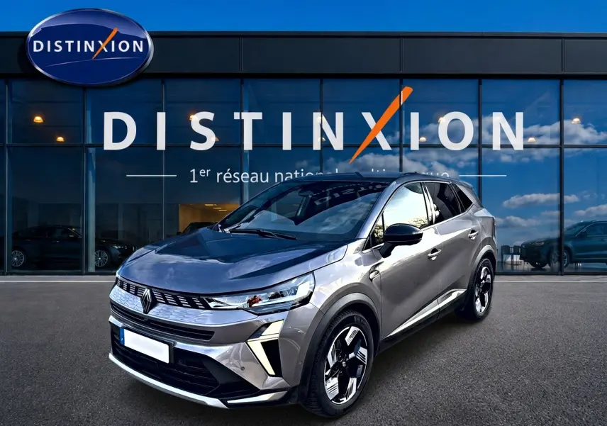 Renault Symbioz gris cassiopée en 3/4 avant droit, avec calandre moderne et jantes bicolores distinctives.