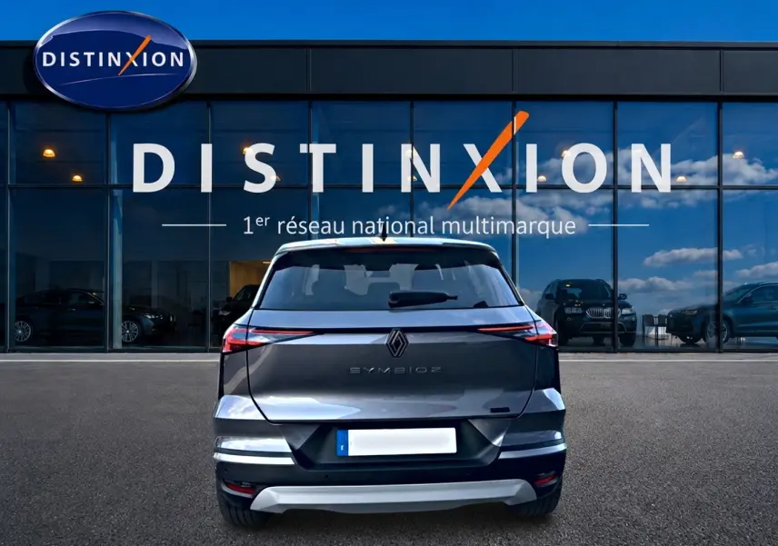 Vue arrière du Renault Symbioz gris cassiopée 2025, avec feux LED fins et logo central sur fond de vitrine Distinxion.