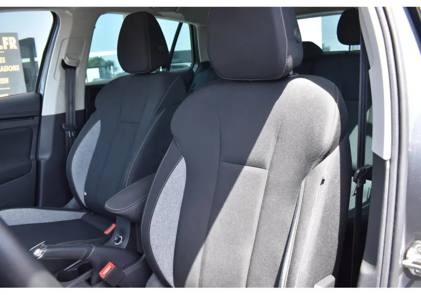 Vue intérieure rapprochée des sièges avant en tissu noir et gris clair du Skoda Scala 2025, côté conducteur ouvert.