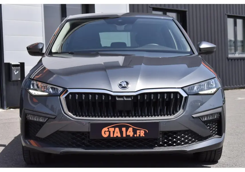 Vue avant d'une Skoda Scala 2025 en gris graphite métallique avec calandre noire et phares LED allumés.