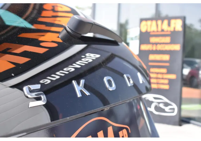 Gros plan sur l'arrière d'une Skoda Scala gris graphite métallisé avec logo SKODA en relief et caméra de recul visible.