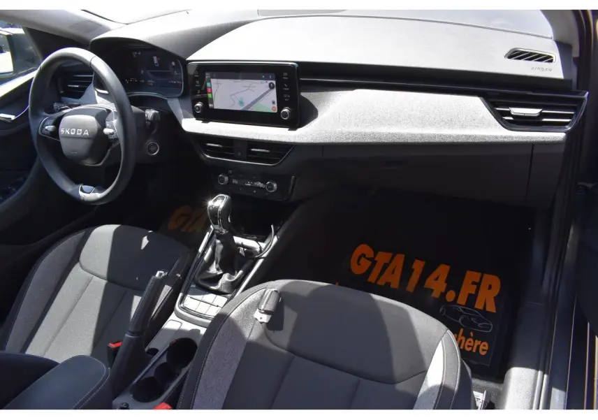 Vue intérieure côté conducteur de la Skoda Scala 2025 avec tableau de bord noir et écran tactile central.