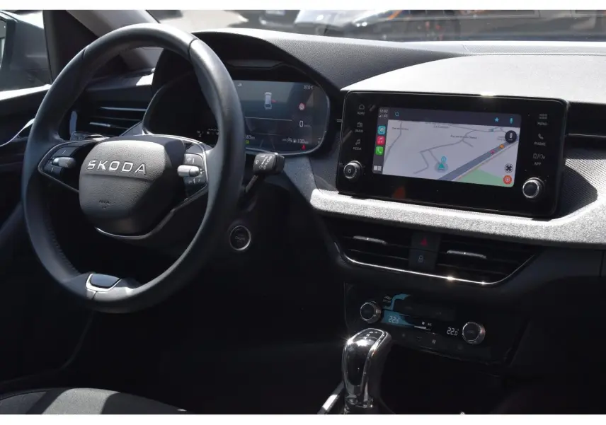 Vue intérieure côté conducteur du Skoda Scala 2025, tableau de bord avec écran tactile et volant multifonctions noir.