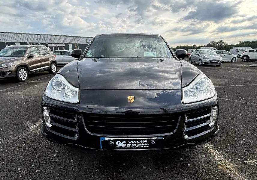 Vue frontale d'un Porsche Cayenne S 4,8L noir de 2007 avec phares distinctifs et calandre large sur parking extérieur.
