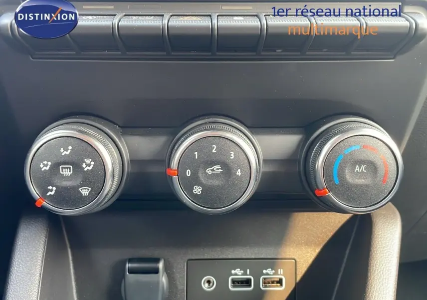 Gros plan sur les commandes de climatisation manuelle de la Renault Clio gris schiste, avec trois boutons ronds et ports USB.
