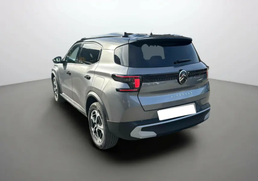 Vue 3/4 arrière droite d'un Citroën C3 Aircross gris mercury avec toit noir et vitres surteintées.