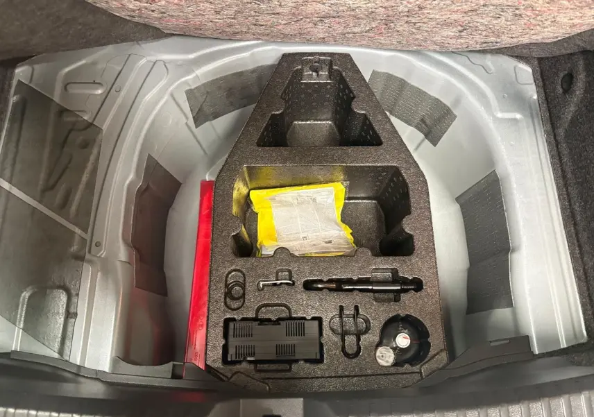 Coffre ouvert montrant le rangement d’outils et accessoires sous le plancher d’une SEAT Ibiza gris magnétique 2024.
