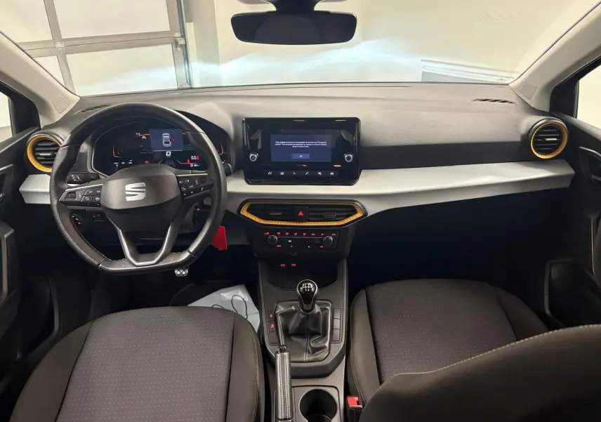 Intérieur de la SEAT Ibiza 2024 gris magnétique, vue frontale du tableau de bord avec volant et console centrale manuelle.