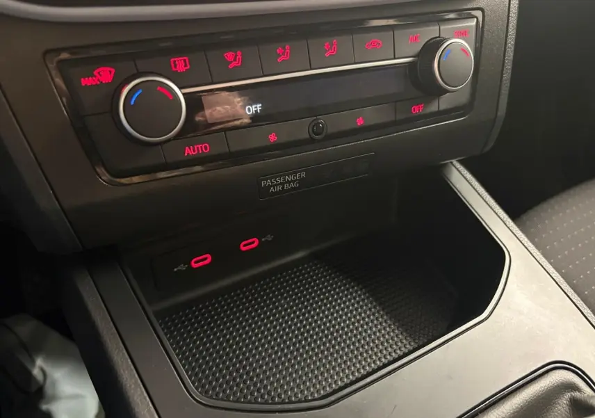 Gros plan sur la console centrale de la SEAT Ibiza 2024 gris magnétique, montrant la climatisation et deux ports USB.