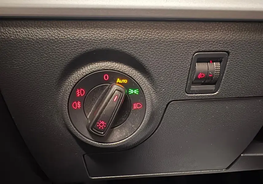 Détail du sélecteur de phares avec réglage automatique sur le tableau de bord noir d'une SEAT Ibiza 2024.