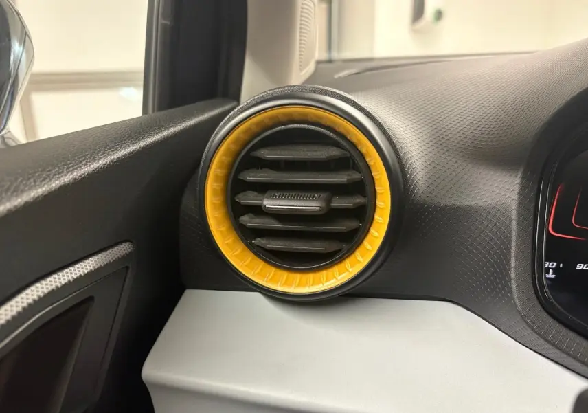 Détail de la sortie d’air ronde avec cerclage jaune sur le tableau de bord côté gauche de la SEAT Ibiza 2024 gris magnétique.