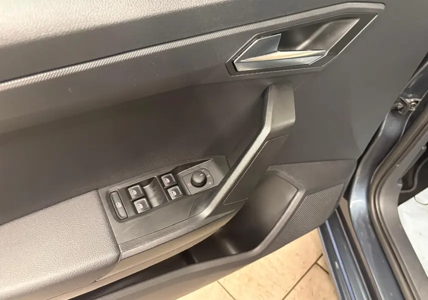 Intérieur côté conducteur de la SEAT Ibiza 2024 gris magnétique, avec commandes des vitres et rétroviseurs sur la portière ouverte.