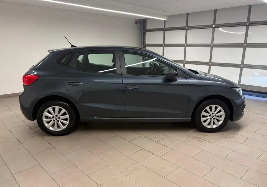 SEAT Ibiza 2024 gris magnétique vue de profil côté gauche dans un garage, jantes alliage et lignes épurées.