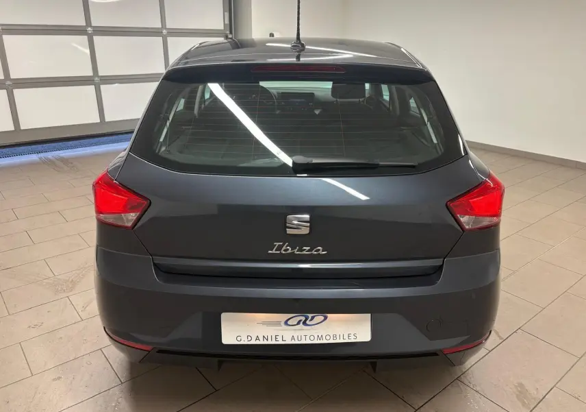 Vue arrière d'une SEAT Ibiza 2024 gris magnétique, avec feux rouges anguleux et logo distinctif sur hayon.