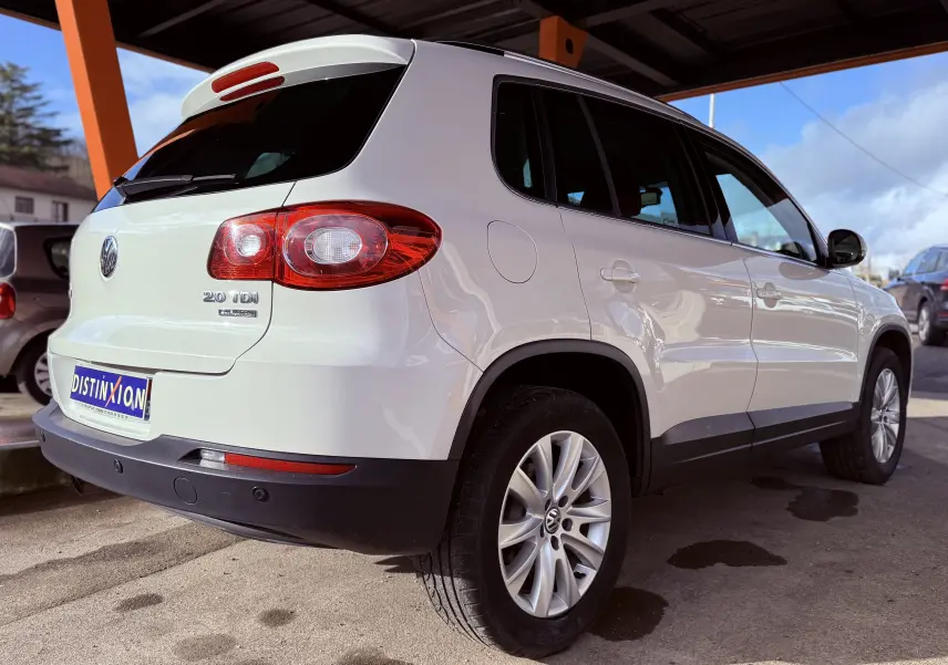 Vue 3/4 arrière droit d’un Volkswagen Tiguan blanc 2.0 TDI 140 avec jantes alliage sous abri.