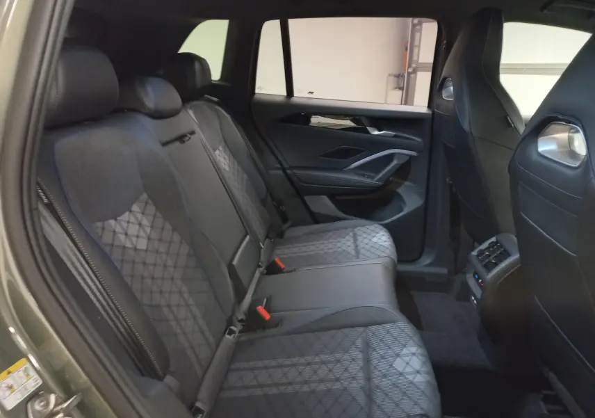 Vue intérieure des sièges arrière du Volkswagen Tiguan 2025, finition Black R-Line, avec sellerie en tissu et cuir noir.